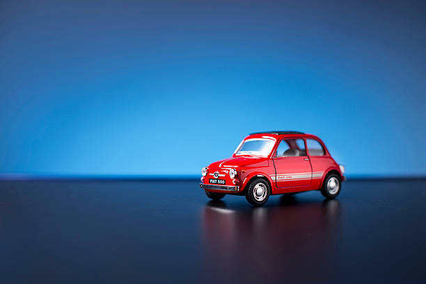 Old Fiat 500 toy car Izmir, Turkey - August 20, 2015 Old Fiat 500 toy car product shot on a blue background little fiat car stock pictures, royalty-free photos & images