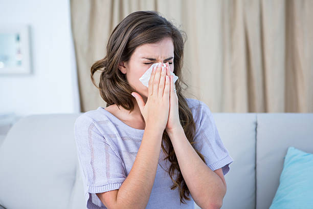 istock Sick woman blowing her nose 484977380