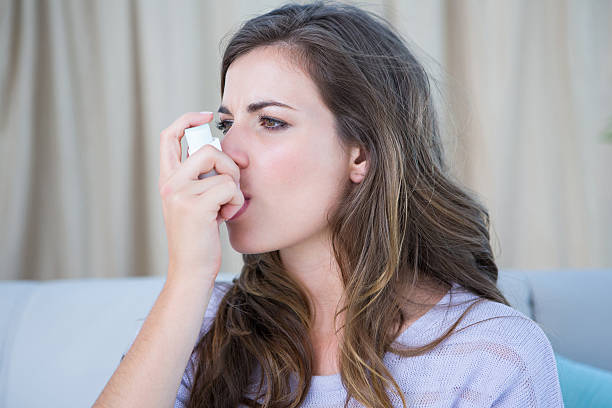 istock Pretty woman taking her inhaler 484979652