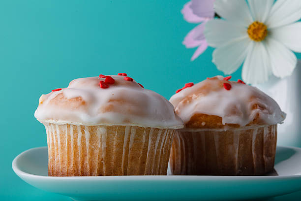 Colorful muffin on saucer with flower.  Selective focus