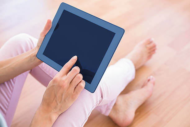 istock Pretty blonde woman using her tablet on the couch 484987876