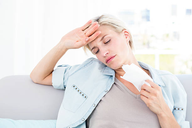 istock Sick blonde woman sitting on the couch 484988328