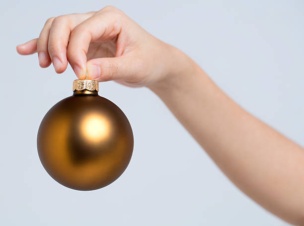 istock Christmas ball holding by fingers 484989498