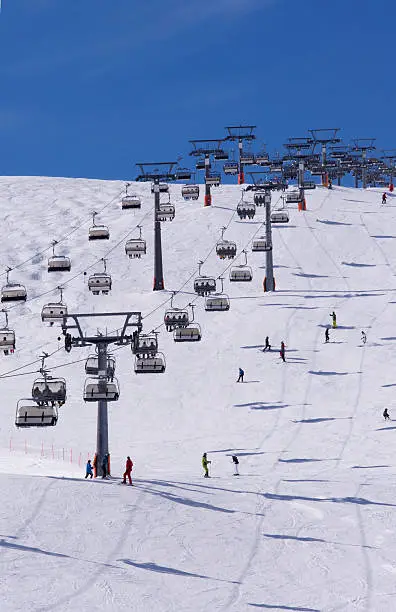 Skiers and double chairlift in Alpine ski resort in Solden in Otztal Alps, Tirol, Austria