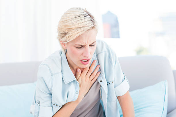 Pretty blonde woman having breath difficulties Pretty blonde woman having breath difficulties in the living room asthmatic photos stock pictures, royalty-free photos & images