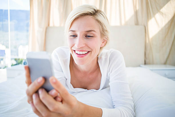 istock Smiling blonde texting with her mobile phone 484993994