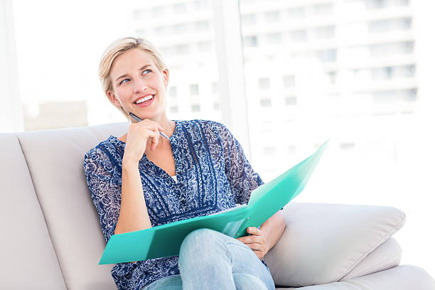 istock Pretty blonde woman taking notes on the couch 485001192