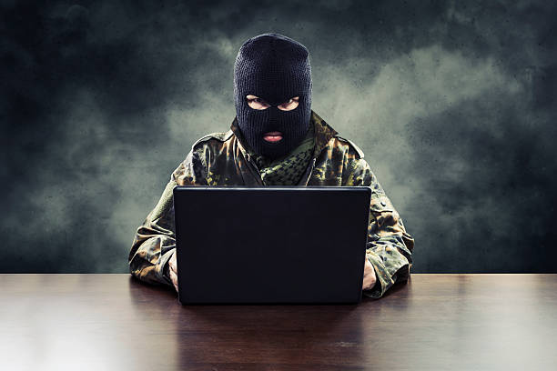Cyber terrorist in military uniform Masked cyber terrorist in military uniform hacking army intelligence terrorism stock pictures, royalty-free photos & images