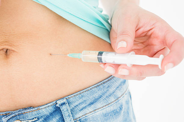 istock Woman injecting fluid in her stomach 485001732