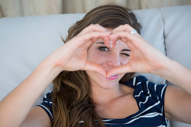 istock Smiling brunette making heart with her hands 485002498