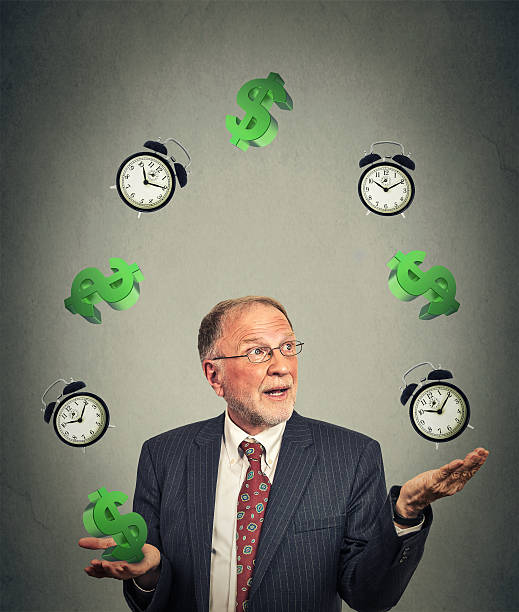 istock business man juggling multiple alarm clocks and dollar sings 485006488