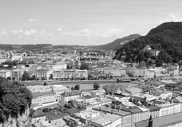 View across the Austrian city of Salzburg View across the European city of Salzburg in Austria. Looking east over the Salzach river to Elisabethkai and the cityscape beyond - monochrome processing. Kapuzinerberg stock pictures, royalty-free photos & images