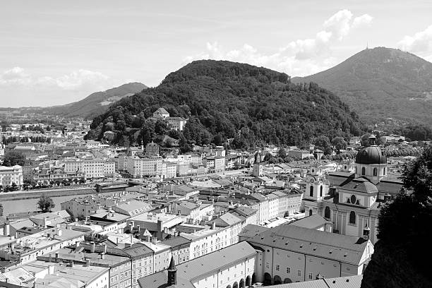 Kapuzinerberg stands in the middle of Salzburg city The tree-covered hillside of Kapuzinerberg stands in the middle of Salzburg city. The Salzach river runs through the Baroque city and Gaisberg mountain stands in the distance - monochrome processing. Kapuzinerberg stock pictures, royalty-free photos & images