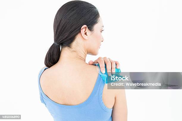 Beautiful Brunette Putting Gel Pack On Shoulder Stock Photo - Download Image Now - 2015, 30-34 Years, 30-39 Years