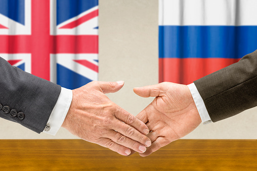 Representatives of the UK and Russia shake hands