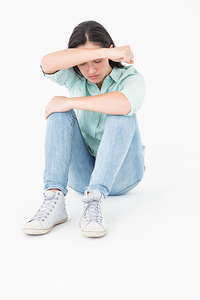 istock Sad woman sitting on the floor and hiding her face 485007532