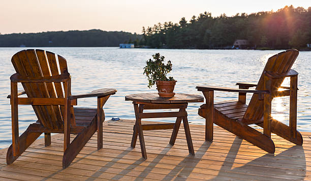 istock Chairs on a deck overlooking a lake at sunset 485010492