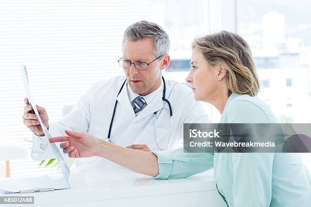 Doctor Having Conversation With His Patient And Holding Xray Stock Photo - Download Image Now