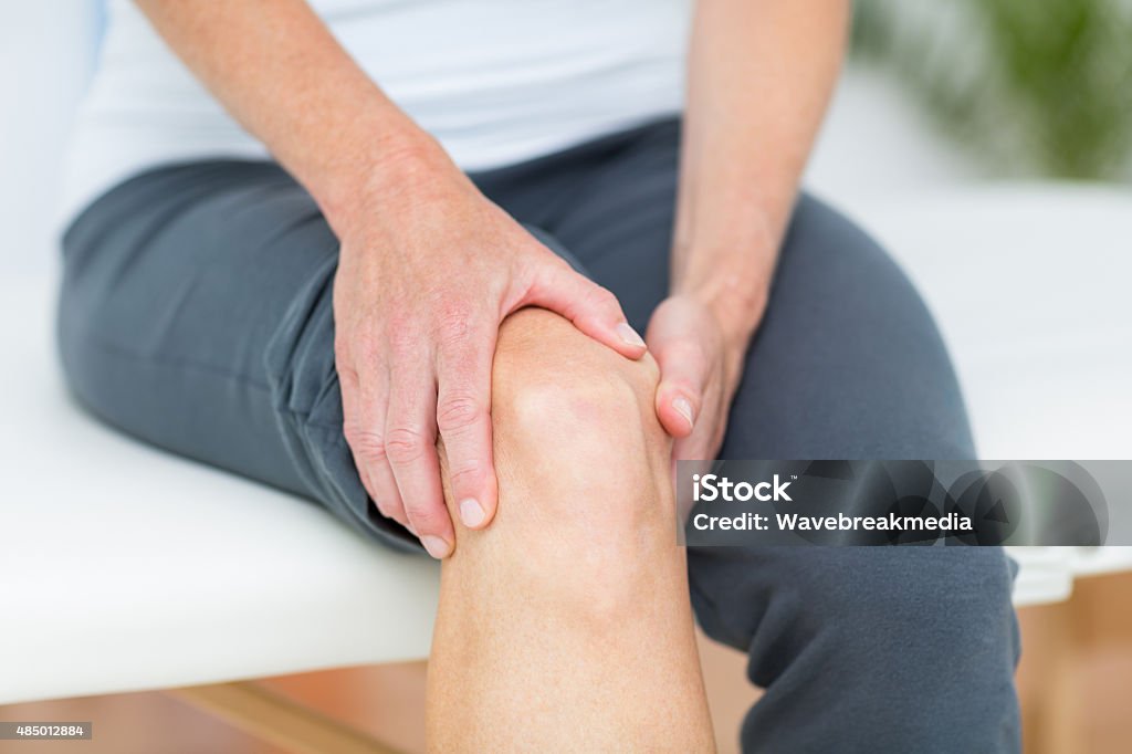 Woman having knee pain Woman having knee pain in medical office Pain Stock Photo