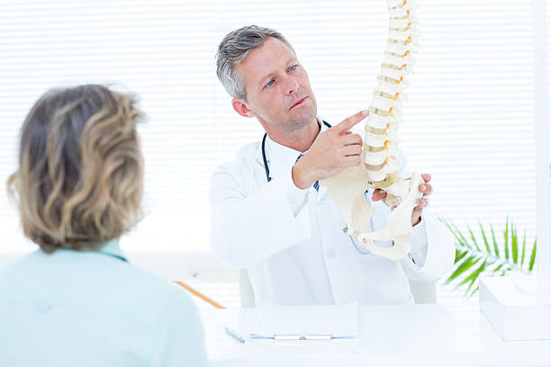 istock Doctor showing spine model to his patient 485013138