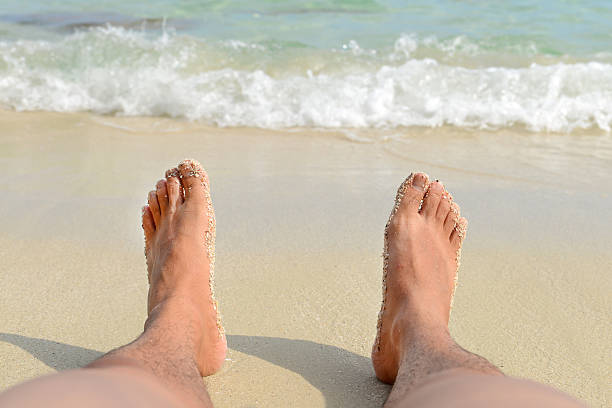 istock Man Bare Feet relaxing on the beach. 485016644