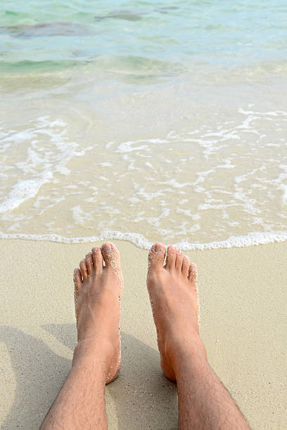 istock Man Bare Feet relaxing on the beach. 485016648