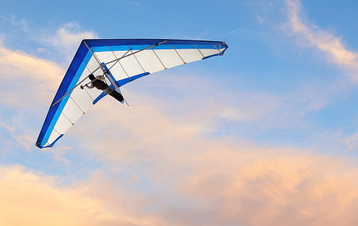 Hang glider fling over the ocean at sunset