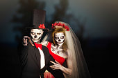 Couple in Halloween skeleton bridal costume does threatening gesture