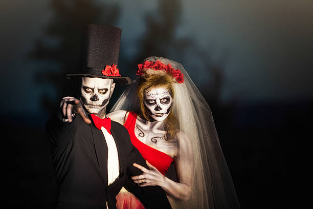 Couple in Halloween skeleton bridal costume does threatening gesture A couple of bridal zombies do not like to be disturbed. The man points to the camera with an angry expression. Shallow DOF with focus on the man. scary bride stock pictures, royalty-free photos & images