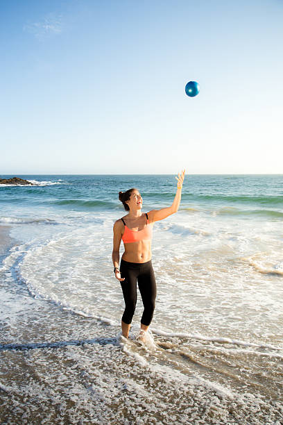 istock Beautiful Caucasian woman playing and practicing yoga at beach 485017578