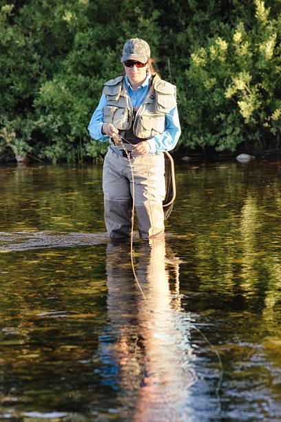 istock Woman fly fishing in river 485017639