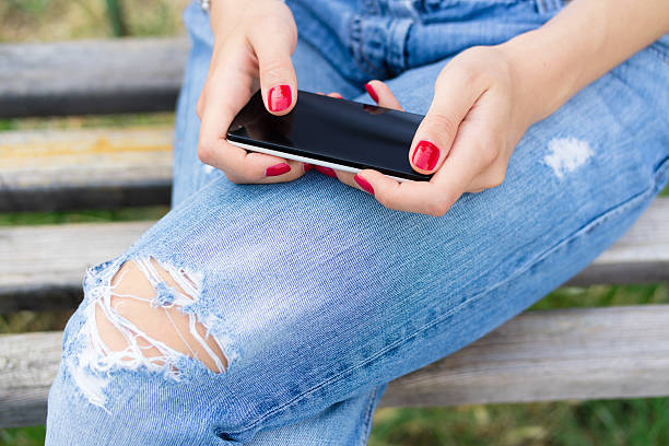 istock Female hands with red manicure holding a cell phone 485021852
