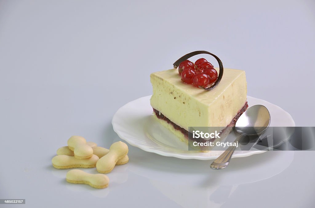 cake,masterpiece a piece of cake with berries,biscuits,white tray of and a silver spoon on a white background on the right Baked Pastry Item Stock Photo
