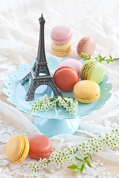 Colorful macaroons on blue plate and a little Eiffeltower