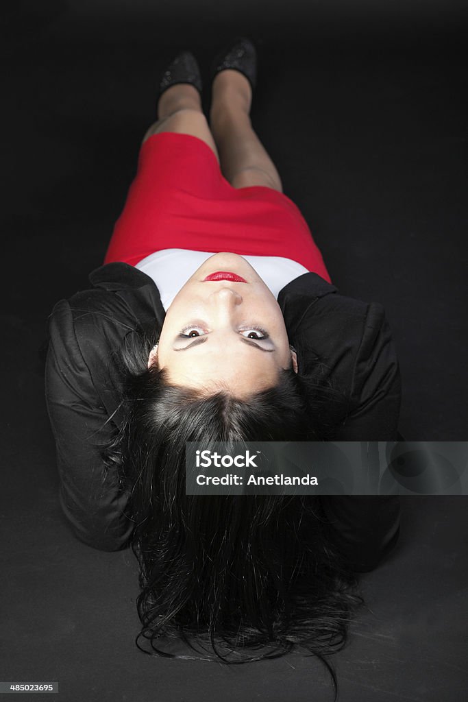 portrait of beautiful young brunette portrait of beautiful young brunette lies on black background. Adult Stock Photo