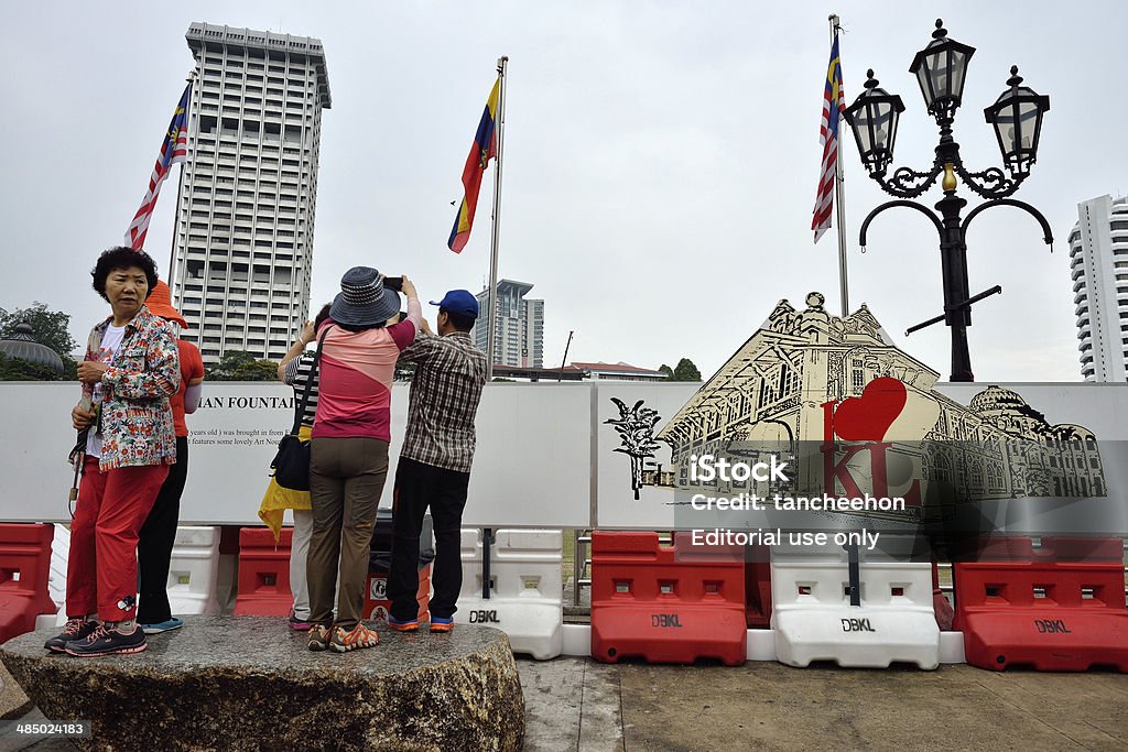 " I Love KL " Kuala Lumpur, Malaysia - April 5, 2014; The Korea tourist was standing on the rock chair and behind them is " I Love KL " white board at Merdeka Square of Kuala Lumpur. Horizontal Stock Photo