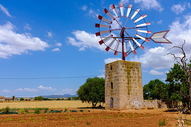 Scenery with traditional windmill in mallorca with blue sky and clouds