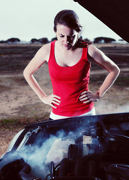 istock Irritated young woman, hands on hips, eyeing smoking,  broken car 485026780