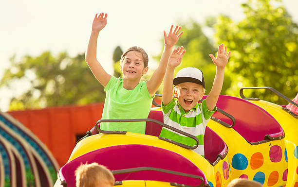 мальчик и девочка на roller coaster на велосипеде в парке - rollercoaster carnival amusement park ride screaming стоковые фото и изображения