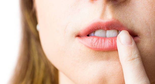 istock Woman pointing to her lips 485033118