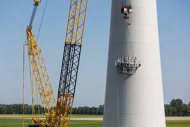 Dutch workers busy with the construction of a big new windturbine