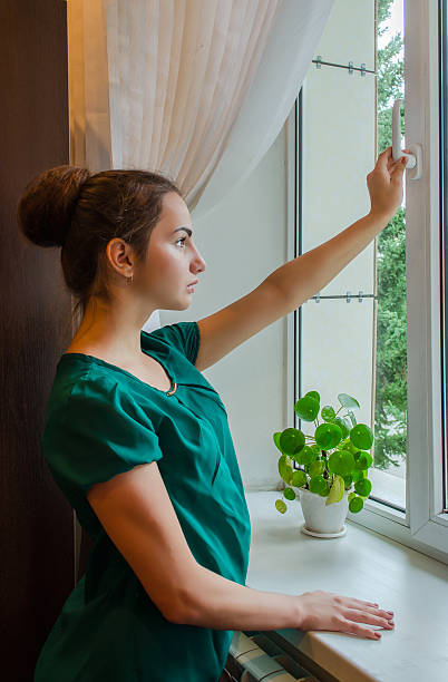 istock young girl opens the window in the office 485040182