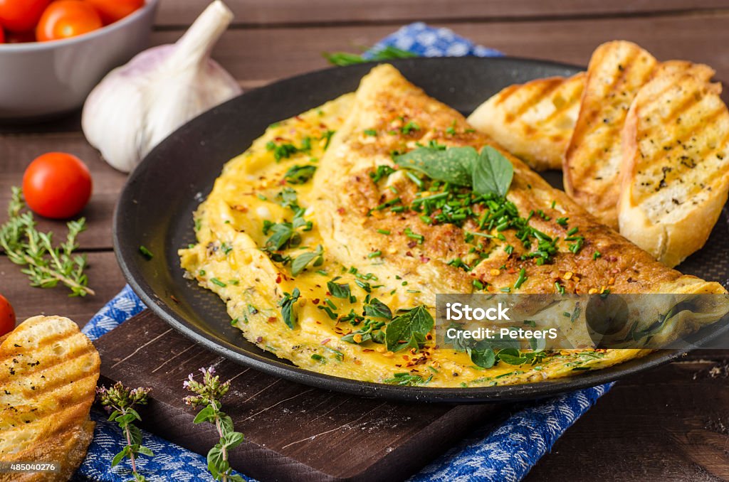 Herb omelette with chives and oregano Herb omelette with chives and oregano sprinkled with chili flakes, garlic panini toasts Omelet Stock Photo