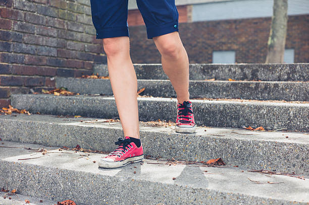 istock Legs of young woman walking down steps 485042382