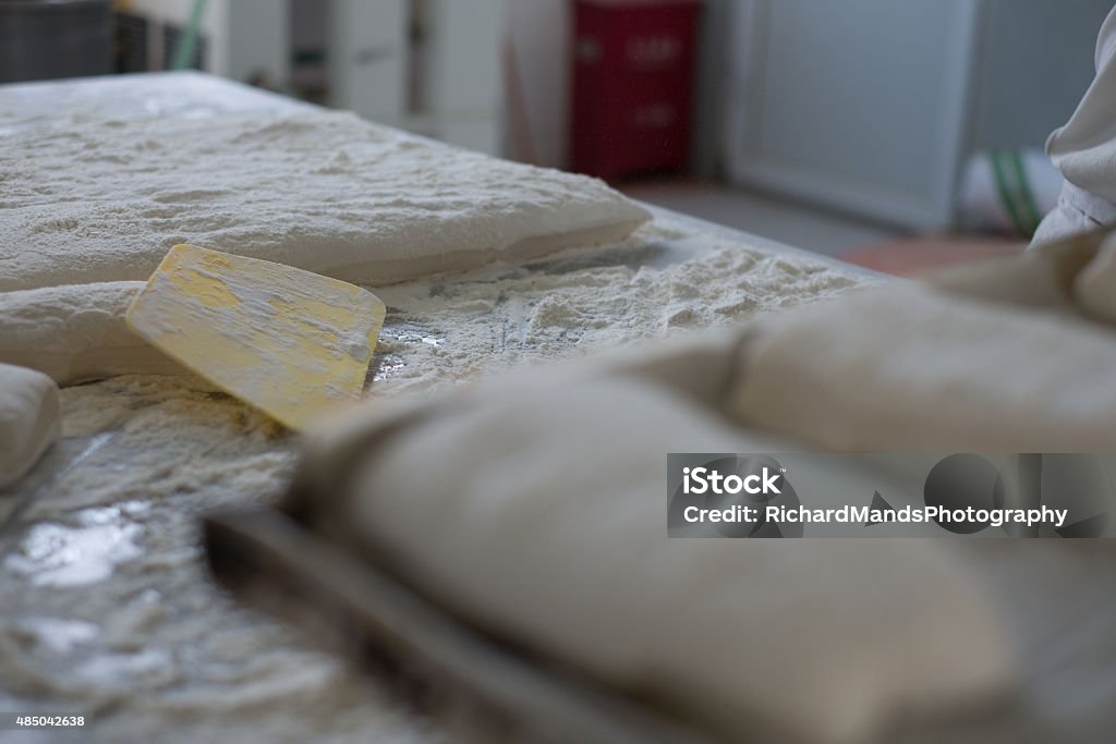 Ciabatta Bread Dough Flat with Yellow Cutter A flat of Ciabatta bread dough flat with a yellow cutter and a tray of individual cut bread rolls. 2015 Stock Photo