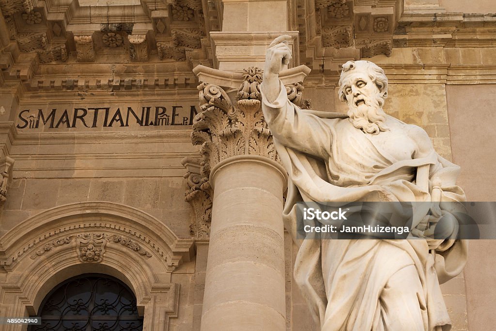 Cathedral in Siracusa, Sicily (Detail with Saint Paul), Italy A detail of the Siracusa Cathedral in Southeast Sicily rebuilt in exuberant Sicilian Baroque style after the damage from the 1693 earthquake. The 17th-century statue is Saint Paul. Famous Place Stock Photo
