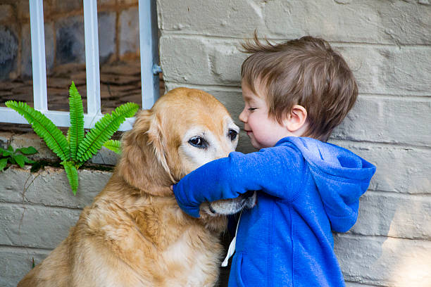 istock Little Boy Hugging His Dog - A Golden Retriever 485046820
