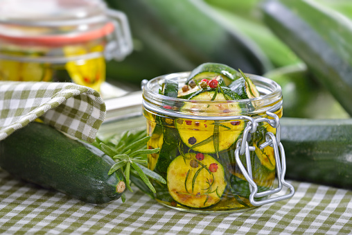 Fried zucchini slices pickled in olive oil with herbs and filled in a canning jar