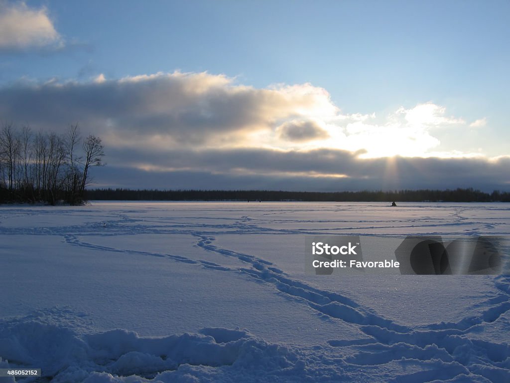 Winter fishing on the Volga Russia. Fishing on the Volga. Frosty, winter day, a ray of sunlight falls on a lonely fisherman.  	 2015 Stock Photo