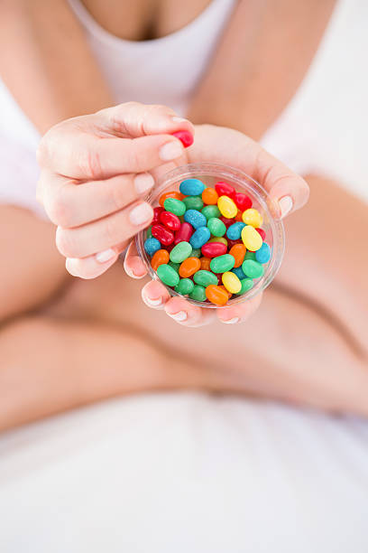 istock Woman holding candies on bed 485052186